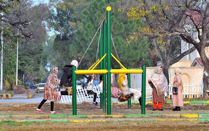 Children enjoying swings at a local park near F6 sector in Federal Capital.