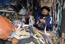 A tailor is repairing zips of jackets and bags at his workplace in Qila Gujjar Singh area