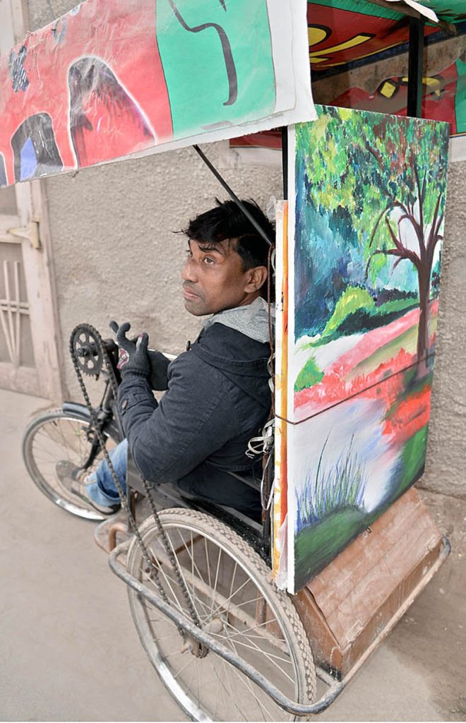 A young disabled artist on his wheelchair selling his handmade painting at Sodiwal Quarter