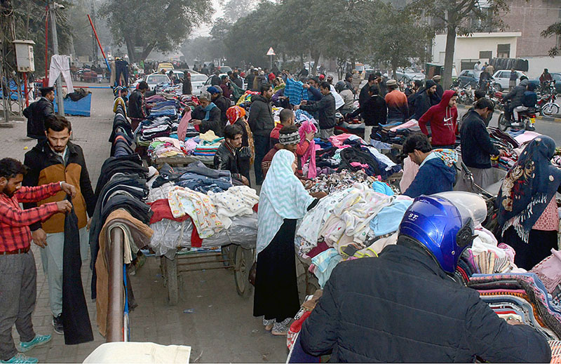 People busy in purchasing used warm clothes from a market at Boharwala Chowk in the city