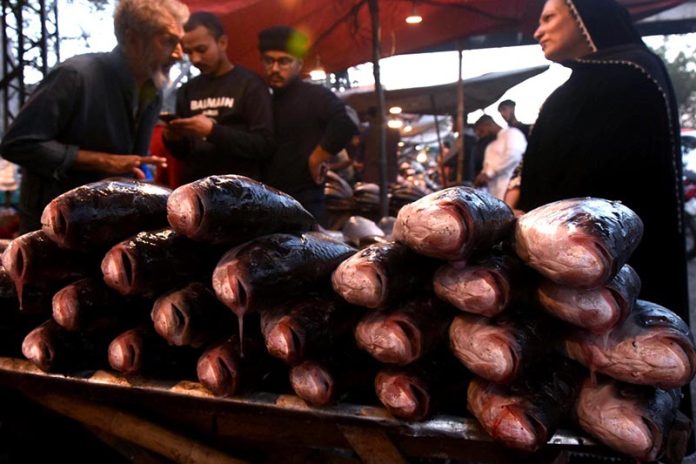 A vendor displaying and selling fishes for customers on the roadside setup as demand increased in the area due to cold weather