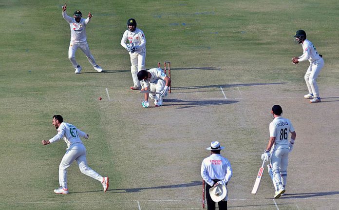 Pakistan's bowler Agha Salman celebrates after the dismissal of New Zealand's Daryl Mitchell (R) during the first day of the second cricket Test match between Pakistan and New Zealand at the National Stadium