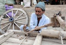 A worker repairing donkey driven cart at his workplace