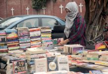 A Girl selecting the books displayed by a vendor at Provincial Capital.