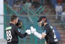 New Zealand's Devon Conway celebrates after scoring century (100 runs) with New Zealand's captain Kane Williamson during the second one-day international (ODI) cricket match between Pakistan and New Zealand at the National Stadium