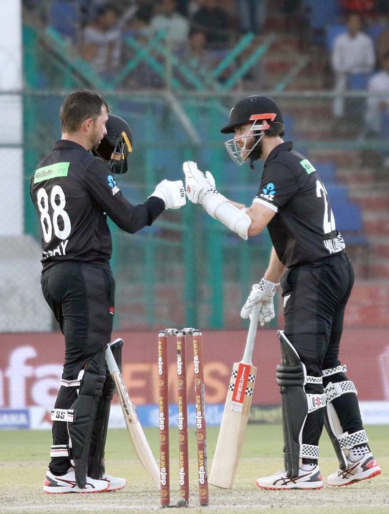 New Zealand's Devon Conway celebrates after scoring century (100 runs) with New Zealand's captain Kane Williamson during the second one-day international (ODI) cricket match between Pakistan and New Zealand at the National Stadium