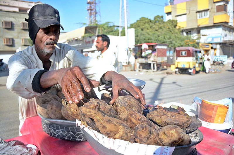 A vendor selling Sweat Potatos at his roadside stall.