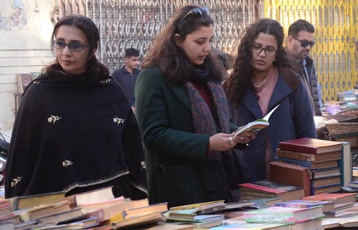 Women selecting old books on a roadside stall at Provincial Capital