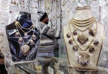 A vendor displaying artificial jewelry to attract the customers at Resham Gali