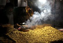 A vendor arranging and displaying the Peanut and different dry fruits on his handcart at Lakhshmi Chowk in the Provincial Capital