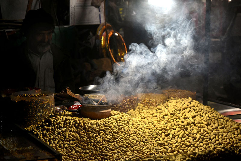 A vendor arranging and displaying the Peanut and different dry fruits on his handcart at Lakhshmi Chowk in the Provincial Capital