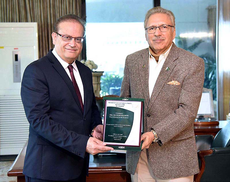 President Dr. Arif Alvi presenting an honorary shield to Mr. Qamar Bashir on his retirement, in appreciation of his services as Press Secretary to the President, at Aiwan-e-Sadr