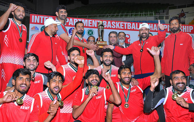 Federal Minister for Inter-Provincial Coordination Ehsan ur Rehman Mazari giving winning trophy to Pakistan Army team who won the Inter Departmental National Basketball Championship title by defeating strong Pakistan Air Force (PAF) with 76-52 points at Pakistan Sports Complex Islamabad