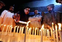 Members of Peace form light candles for the victims of Peshawar suicide blast inside the police line mosque at press club
