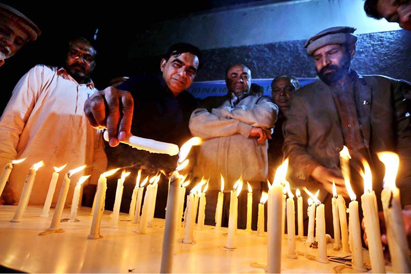 Members of Peace form light candles for the victims of Peshawar suicide blast inside the police line mosque at press club