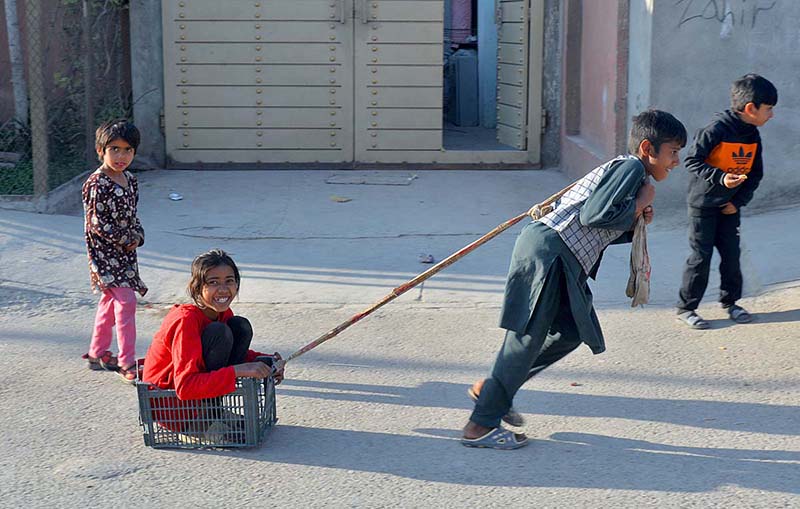 A boy dragging his sister by pulling discarded basket at G-7
