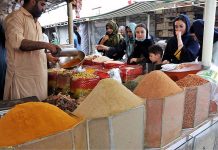 Women purchasing spices from vendor at Sunday Bazaar in Federal Capital