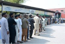 People are standing in a queue to purchase flour bags on subsidized rate initiated by the Government