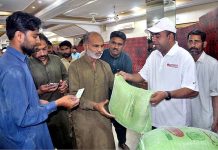 Additional Deputy Commissioner Sargodha Arshad Ahmed Wattoo distributing free flour bags among the deserving people at Choongi No. 9