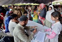 A large number of people standing in queue to be registered for getting free flour bags under Ramadan package at Liaqat Bagh.