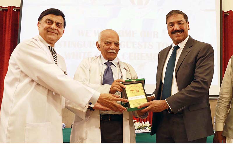 Prof. Dr. Abdur Rasheed Mian, Dean Faculty of Forensic Medicine CPSP, Dean PG Studies WMCR&WDCR giving a shield to Chief Guest Major General (R) Tariq Hussain after the White Coat Ceremony at Watim Medical Dental College