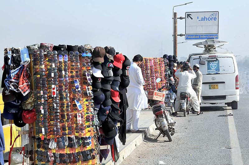 People busy in purchasing sunglasses and caps on Faizabad Flyover