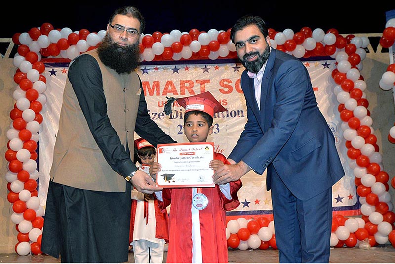 Salman Bashir AGM The Smart School & Colleges and Sheikh Umar Director Smart School Umar Campus giving certificate to student during annual prize distribution ceremony of The Smart School Umar Campus Misrial Road