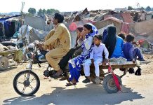Family traveling on a tri-cycle rickshaw at Latifabad