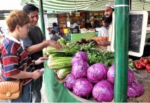 A foreigner couple purchasing vegetables from vendor at Sunday Bazaar in Federal Capital
