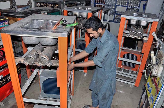 A mechanic busy in making cone ice cream machine in a local factory at Lehtrar Road