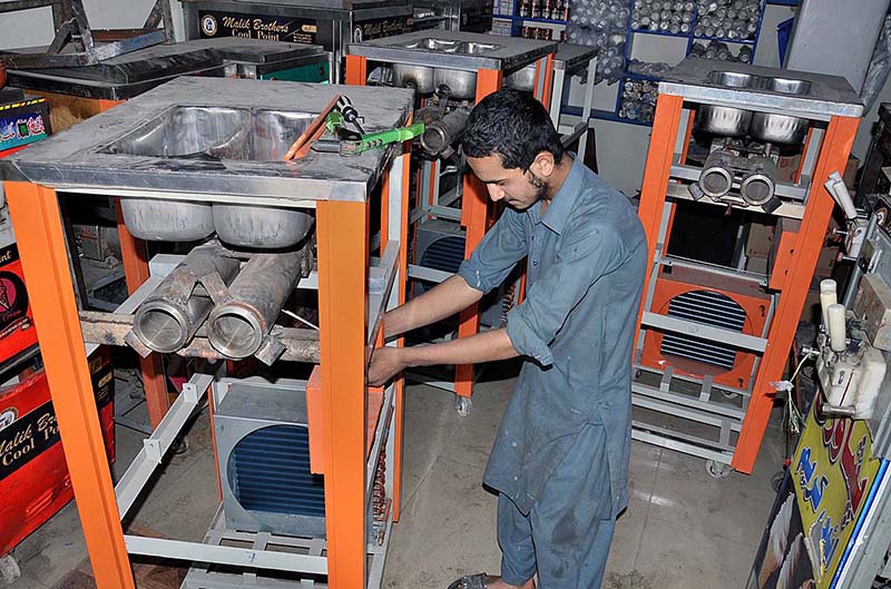 A mechanic busy in making cone ice cream machine in a local