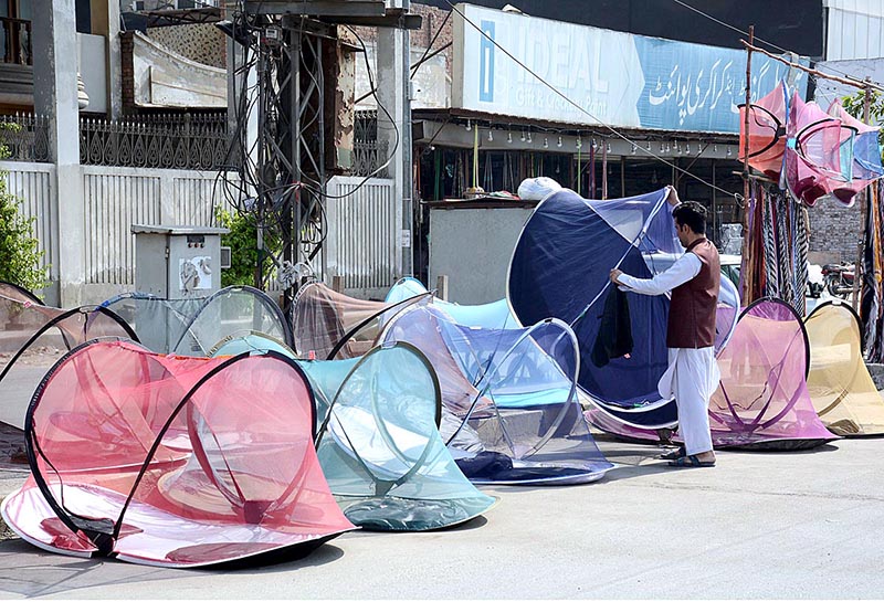 A vendor displaying mosquito nets to attract customers at his roadside setup