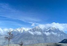 A beautiful view of clouds hovering over the snow covered mountain