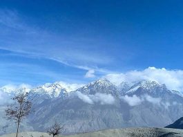 A beautiful view of clouds hovering over the snow covered mountain