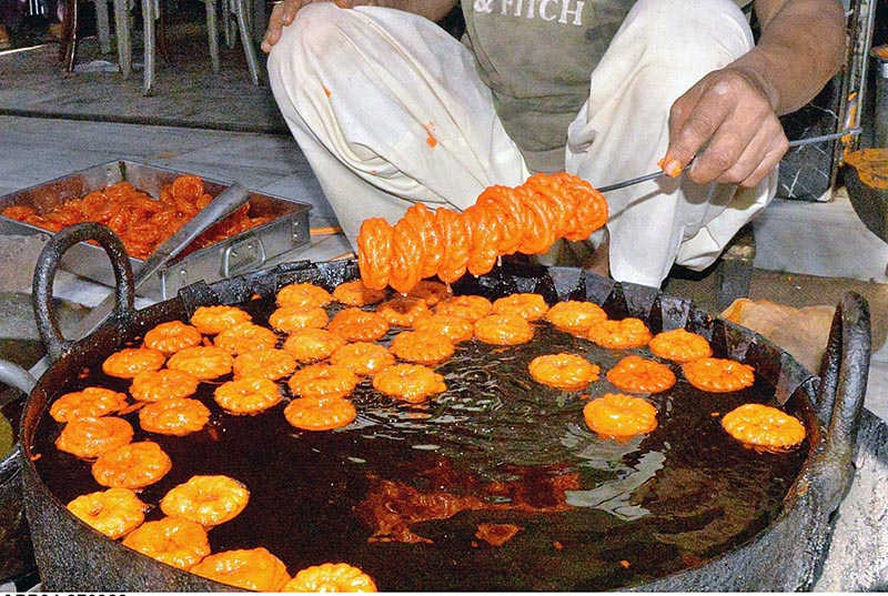 A vendor busy in preparing traditional food item (jalebi) to attract the customers during Holy fasting month of Ramazan