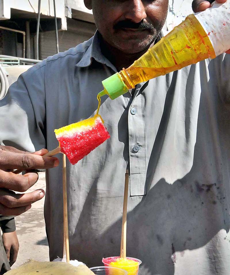 A vendor preparing ice-lolly for customers at his roadside setup in Federal Capital
