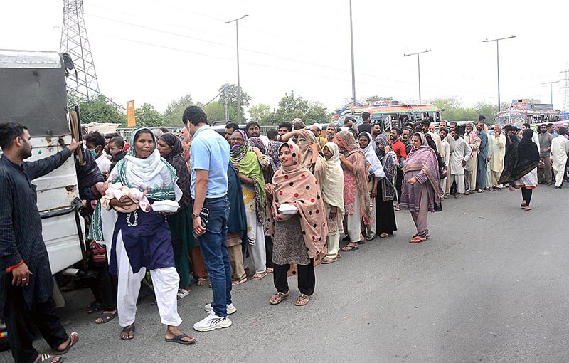 A large number of people standing in queue to collect free food being distributed during Holy fasting month of Ramzan.