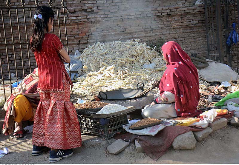 A working woman is sowing grain in the traditional way by the roadside