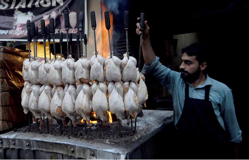 A vendor preparing Traditional chicken roast (Sajji) at his roadside Setup