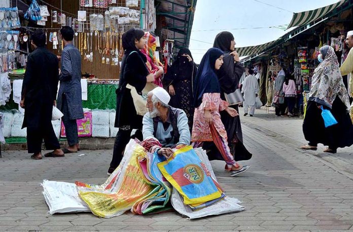 An older man selling shopping bags at Margalla Ramzan Bazar
