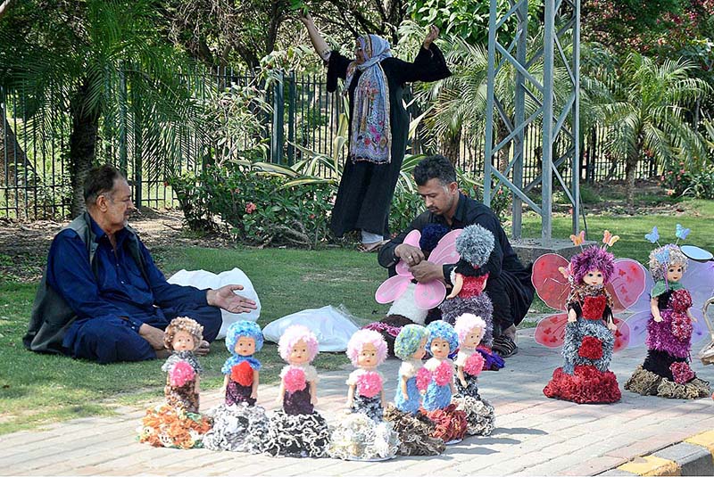 A vendor busy in preparing beautiful doll to sell at his roadside setup