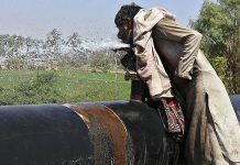 A labor drinking water form water pipeline during his work shift at Tando Yosuf road during a hot day in the city