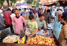 People busy in purchasing traditional food item Samosas from vendors for Iftari during a Holy month of Ramazan
