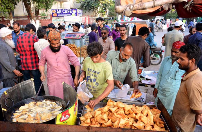 People busy in purchasing traditional food item Samosas from vendors for Iftari during a Holy month of Ramazan