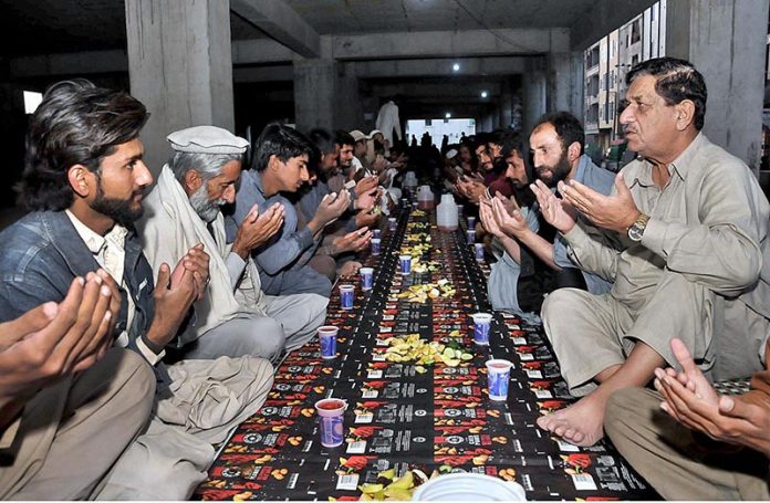 People offering dua before break their fast organized by the volunteers in the Federal Capital