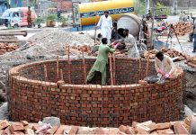 Labourers busy in construction work of sewer manhole at Water Works Road.