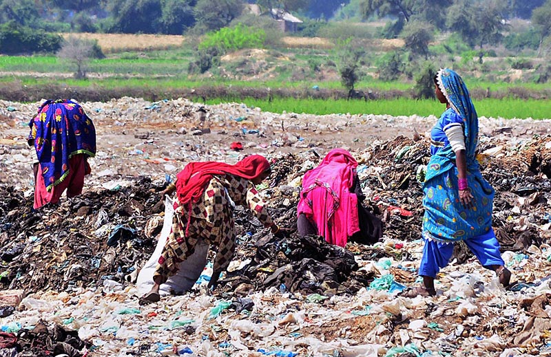 Gypsy women busy in searching the valuables items from garbage at Latifabad