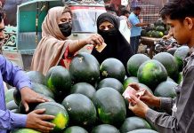 Women purchasing watermelon from vendor on the first day of Holy Fasting Month of Ramzan at Latifabad