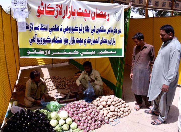 People busy in purchasing fresh vegetables from vendors at Ramzan bachat Bazar during holy month of Ramzan near Railway Station