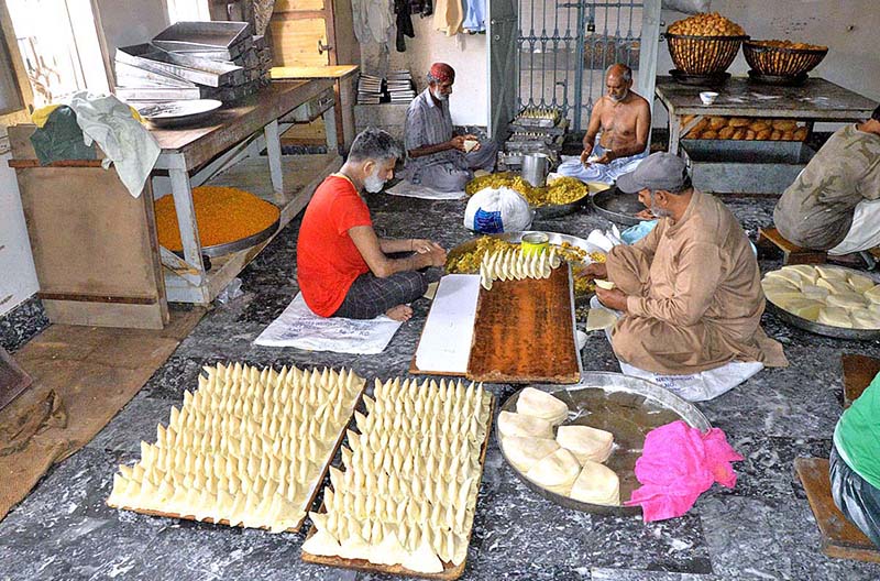 Workers busy preparing traditional items ‘samosa’ on the first day of Holy Fasting Month of Ramzan at Tower Market